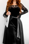 Model wearing the Abyss Lace Long Sleeve Velvet Maxi Dress, a gothic black velvet maxi dress with sheer floral lace sleeves, fitted bodice and dramatic full length silhouette