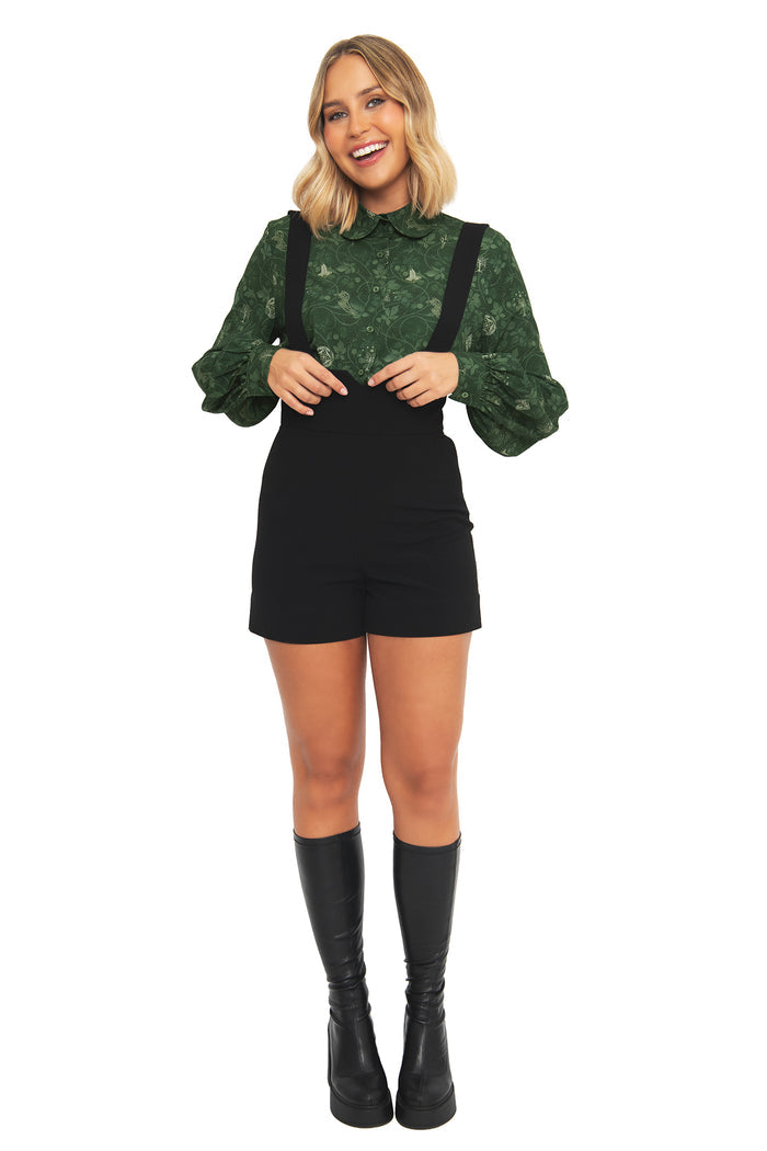 Front view of a model wearing the BlackMilk Bag End Wallpaper Long Sleeve Blouse in deep green, featuring a Peter Pan collar and print inspired by the imagined interiors of Bag End from the Lord of the Rings.
