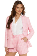 Woman wearing a pink checkered suit with a white shirt on a white background