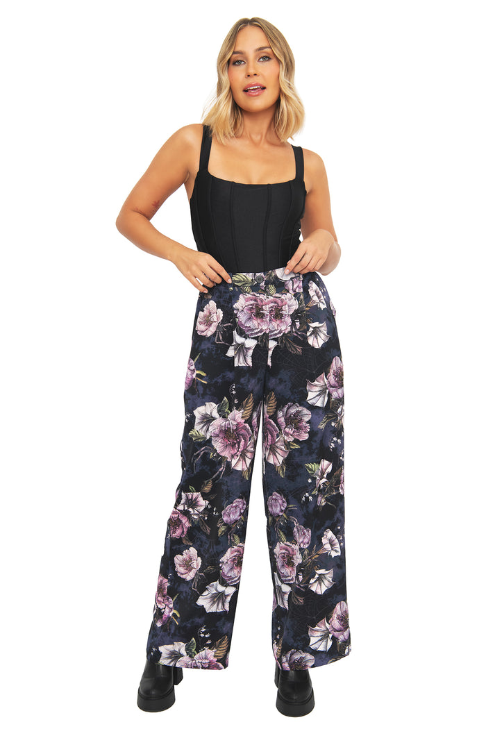 Corporate goth wide leg pants with dark floral artwork and hidden spider details woven through a moody botanical print. These alternative office pants blend dark academia, whimsigoth and gothic fashion with a high-waisted silhouette and relaxed flowing fit.