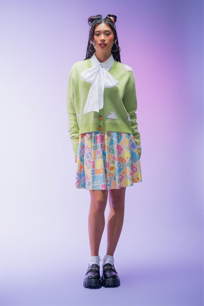 Green cropped knit cardigan featuring an all-over bunny pattern, carrot-shaped buttons and ultra-soft yarn for a cosy cottagecore-inspired layering piece.