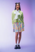 Green cropped knit cardigan featuring an all-over bunny pattern, carrot-shaped buttons and ultra-soft yarn for a cosy cottagecore-inspired layering piece.