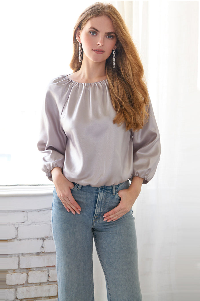 Woman wearing Cameron, a silver Finley blouse with gathered neck and long blouson sleeves