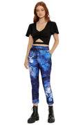 Woman wearing a black crop top and blue galaxy-patterned leggings on a white background