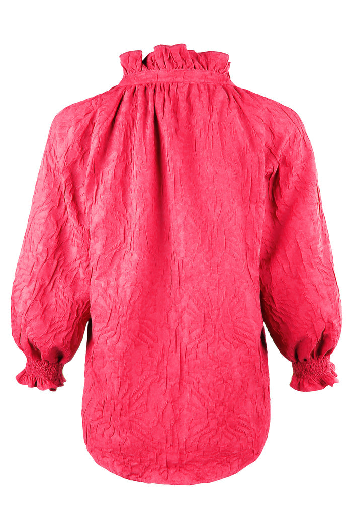 Red textured blouse with long sleeves on a white background