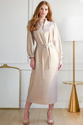 Woman wearing Franchesca, a silver Finley dress in an elegant room with a white wall and gold accents.