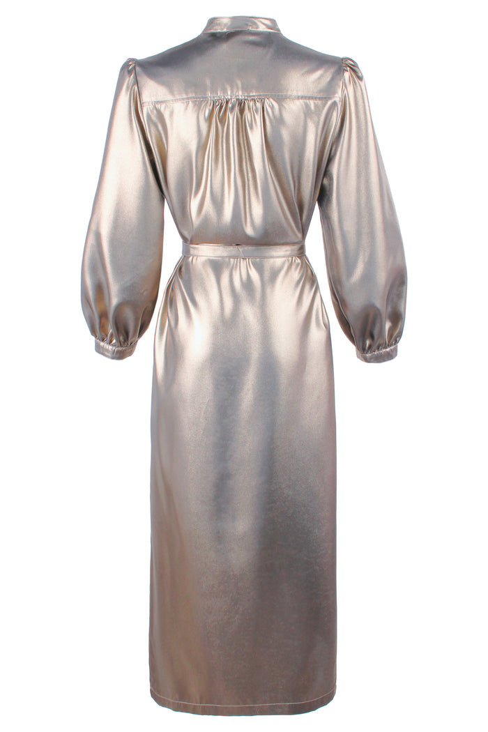 Rear view of Franchesca, a silver Finley dress in an elegant room with a white wall and gold accents.