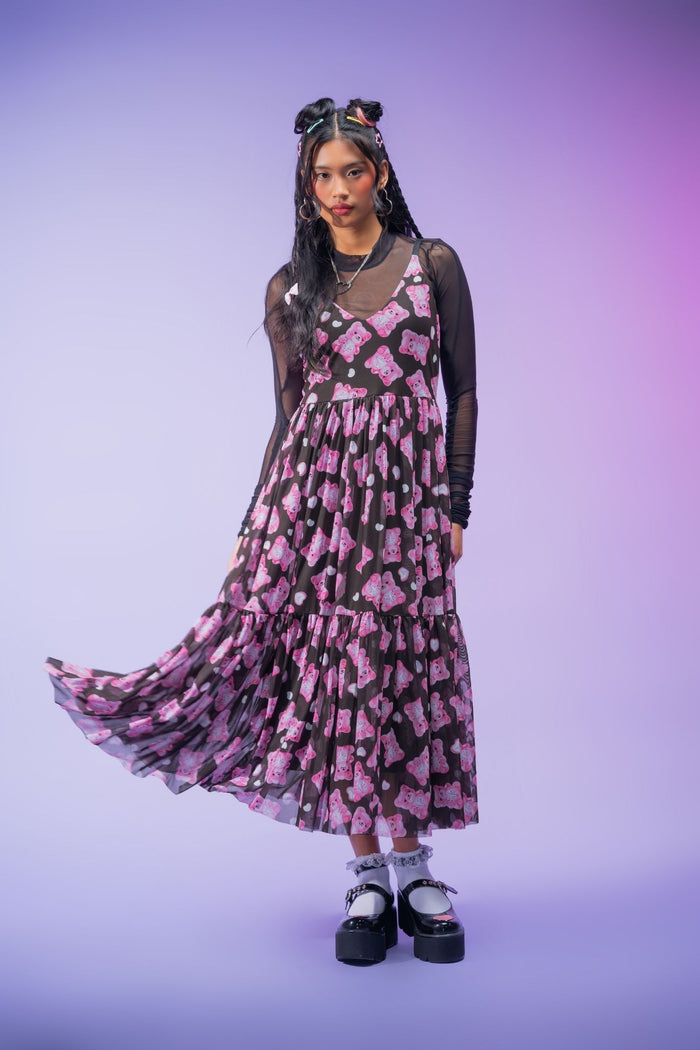 Sheer black mesh midaxi dress featuring an all-over pink gummy bear print, adjustable straps, floaty layered fabric and a lined skirt for a playful alternative look.