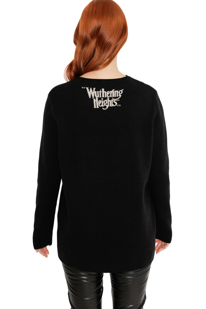 Detail view of the His and Mine High Neck Sweater from the Wuthering Heights collection, highlighting the black knit texture, illustrated house and romantic gothic typography