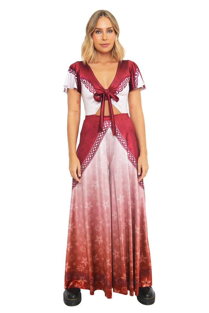 Front view of a model wearing the BlackMilk I Am No Man Rio Jumpsuit in burgundy red, featuring wide flowing rio sleeves and a tie-front crop top, inspired by Éowyn from the Lord of the Rings.