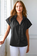Model wears Finley Jenny black silky poplin top with ruched ruffle detail and stand collar.