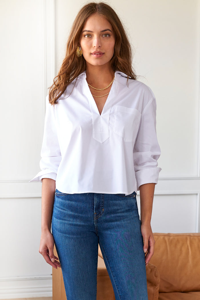 Model showcases Finley Joni poplin top with long sleeves, V-neck, and a relaxed, boxy silhouette