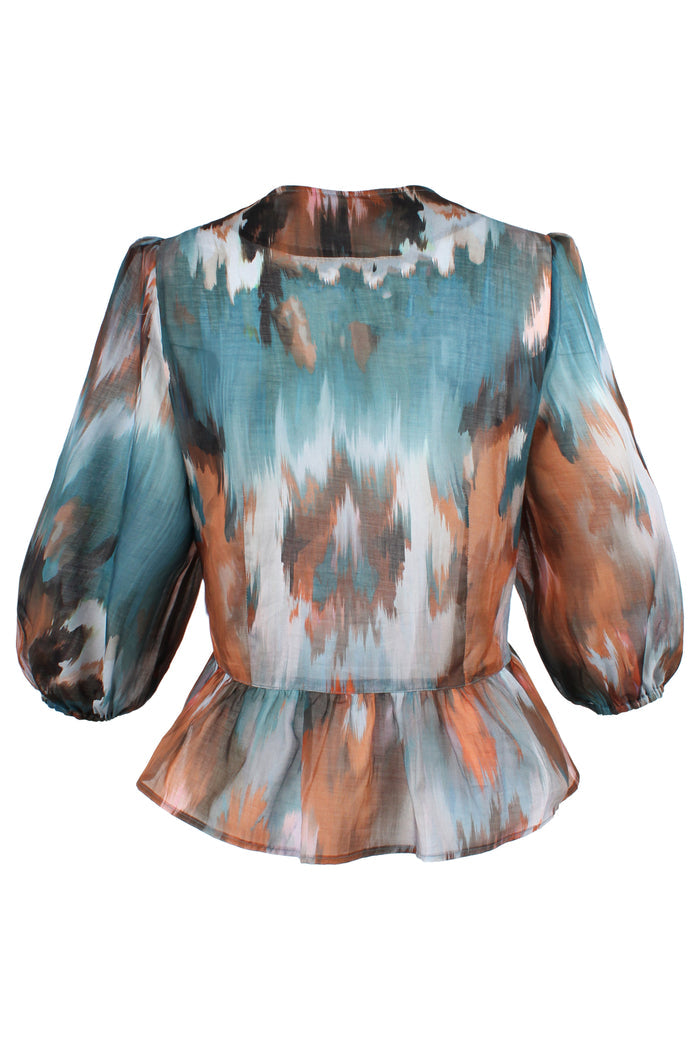 Rear view of the Finley Luna blouse, a peplum hem tie front puff sleeve blouse in green floral pattern.