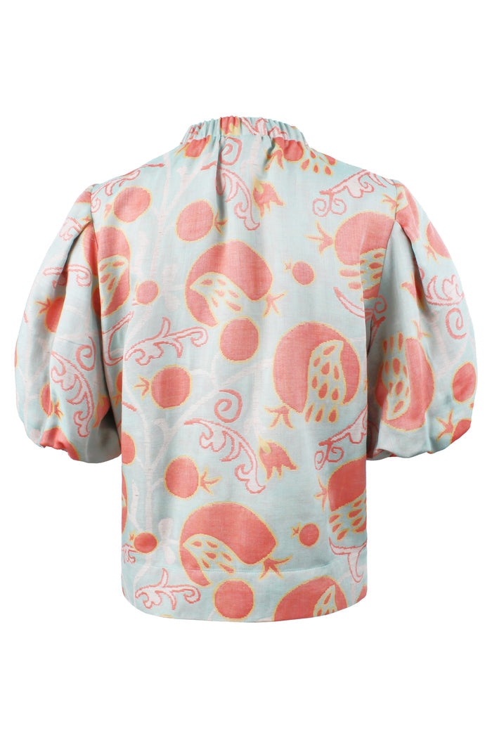 Light blue blouse with pink floral pattern on a white background