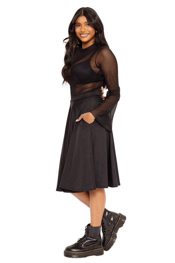 High-waisted black midi skirt with practical pockets, combining timeless style and all-day comfort for work outfits, casual dressing and day-to-night wear.