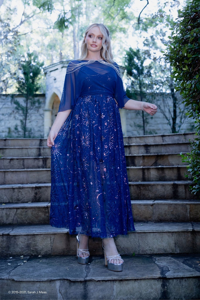 ACOTAR navy starburst sequin maxi dress with cape, inspired by A Court of Thorns and Roses series by Sarah J Maas, featuring sheer mesh overlay, scattered sequin stars, V neckline, adjustable straps and flowing skirt, Night Court fantasy gown