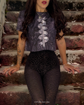Model sitting on stone steps wearing a cropped, fitted T-shirt with a marbled dark print and a central sword and ribbon graphic featuring inspired quotes from A Court of Thorns and Roses (ACOTAR), paired with high-waisted black patterned leggings.
