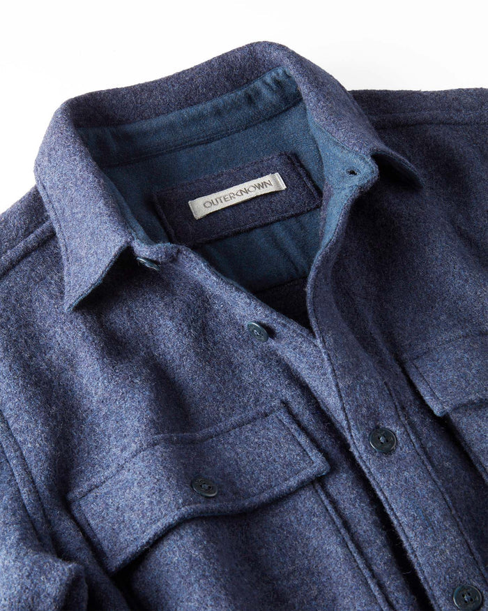 Close-up of a blue coat with a brand label on a white background