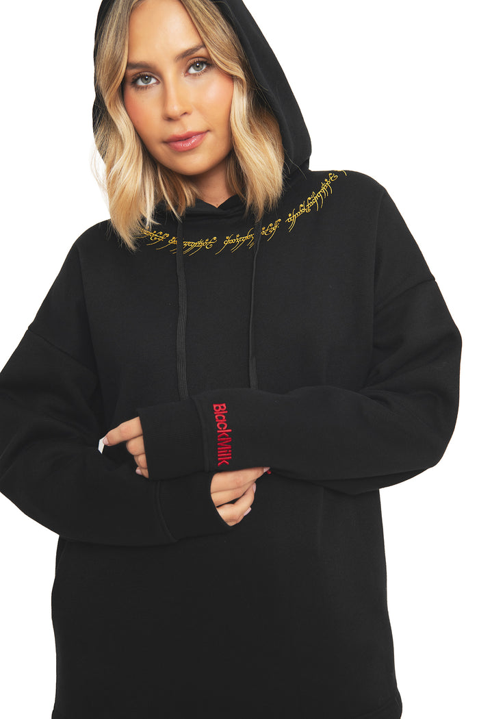 Close-up of the ribbed cuff and hood on the BlackMilk x Lord of the Rings One Ring hoodie, showing the red BlackMilk branding at the wrist and gold Black Speech embroidery at the neckline of this oversized streetwear sweatshirt.