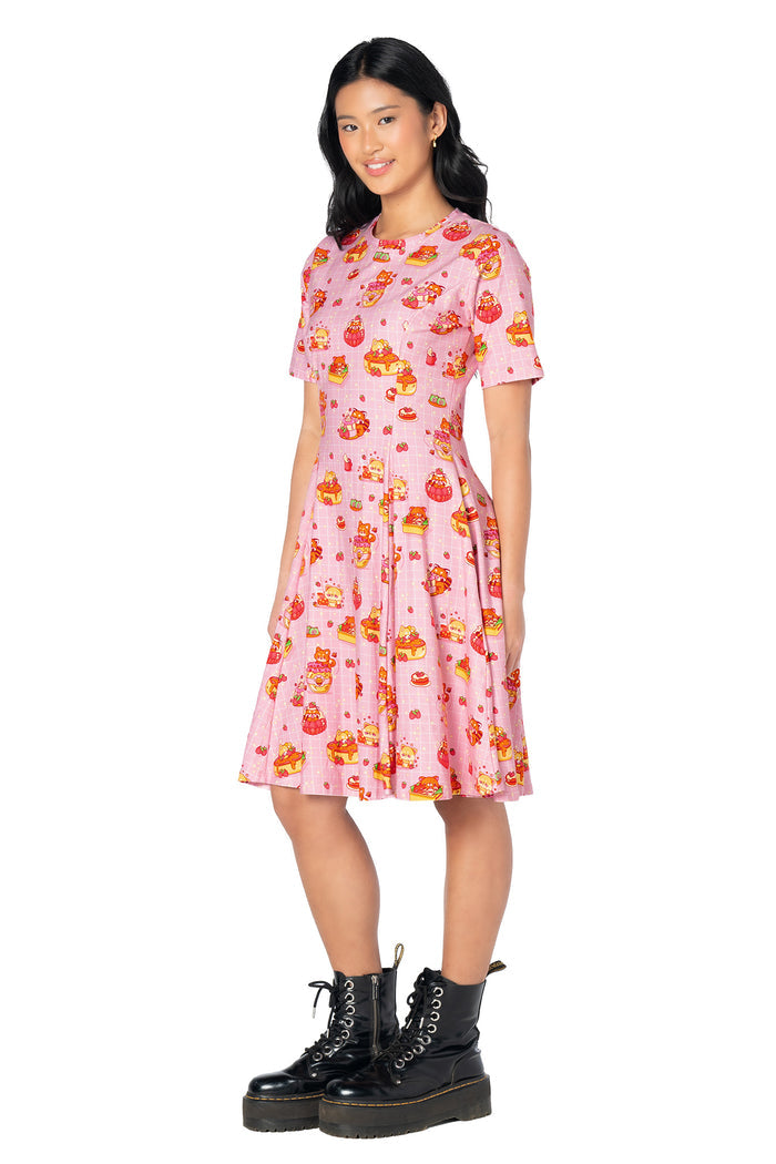 Women's pastel pink tee dress featuring playful bunny artwork, strawberries, cakes and café-inspired illustrations with a knee-length casual silhouette.