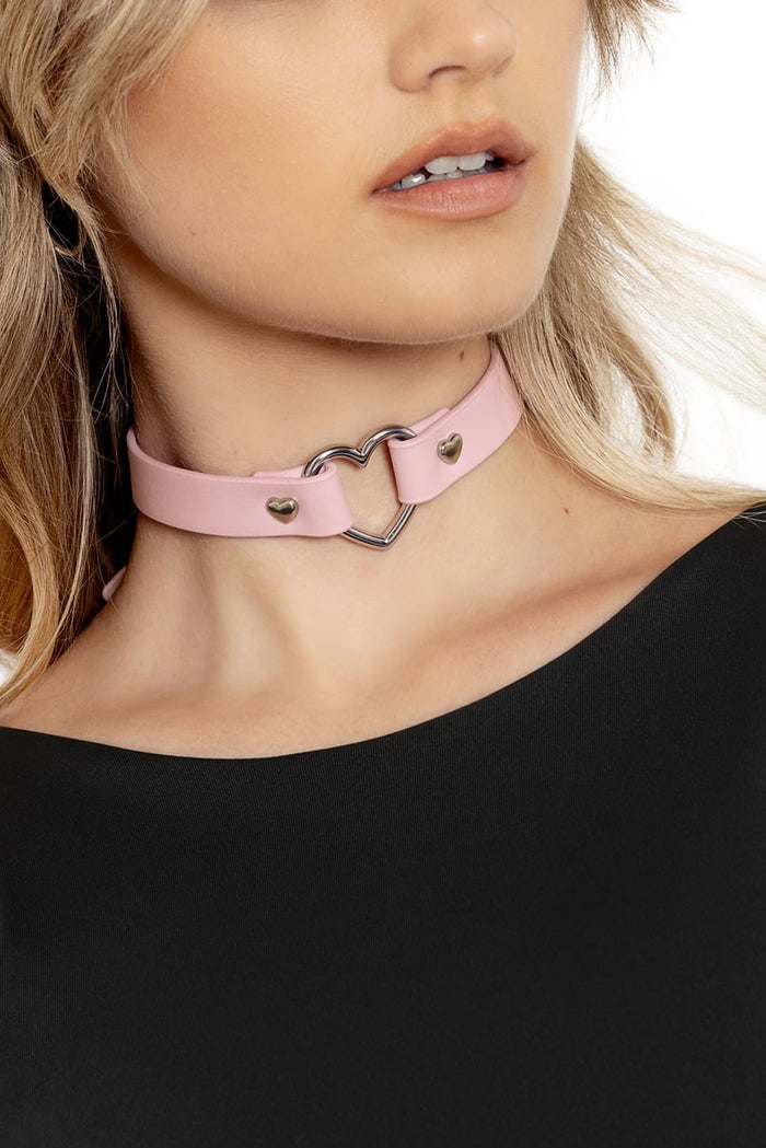 A person wearing a black top and a pink heart-shaped choker with an adjustable strap.