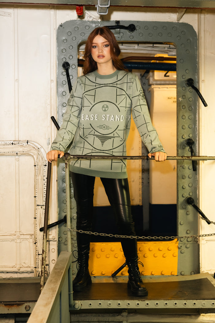 Person wearing a green sweater with text inside a metal frame.
