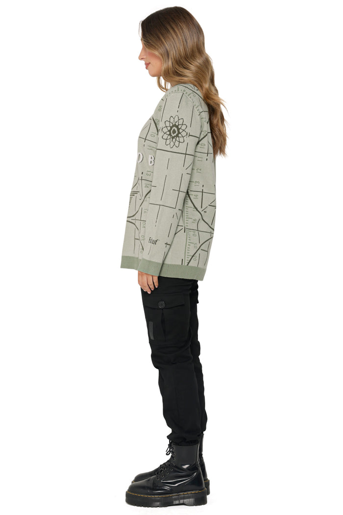 Model wearing Fallout x BlackMilk Please Stand By Oversized Knit Sweater in sage green featuring retro Fallout test screen design.