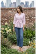 Model wearing the Finley Rocky blouse, a tie front relaxed fit poplin pink blouse