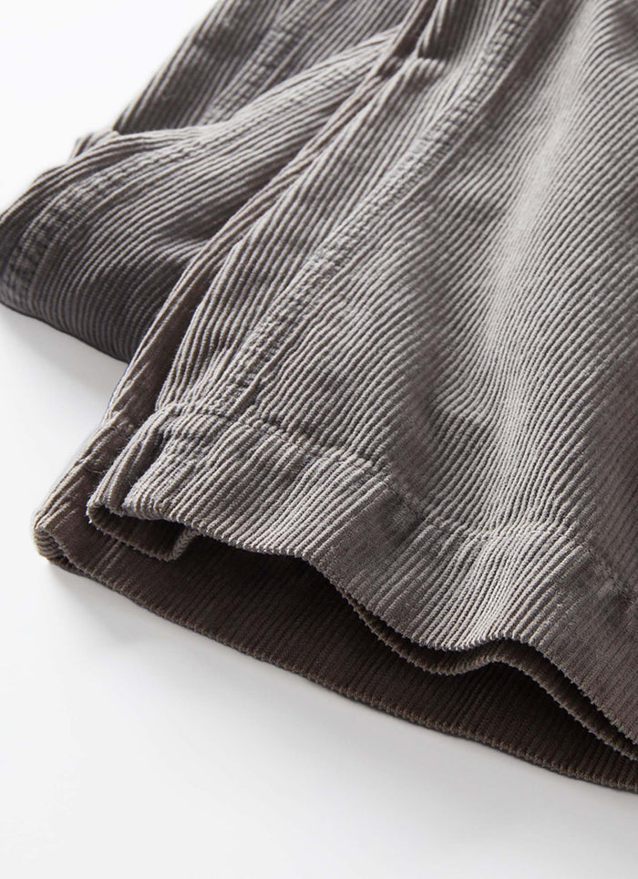 Close-up of folded gray corduroy pants on a white background
