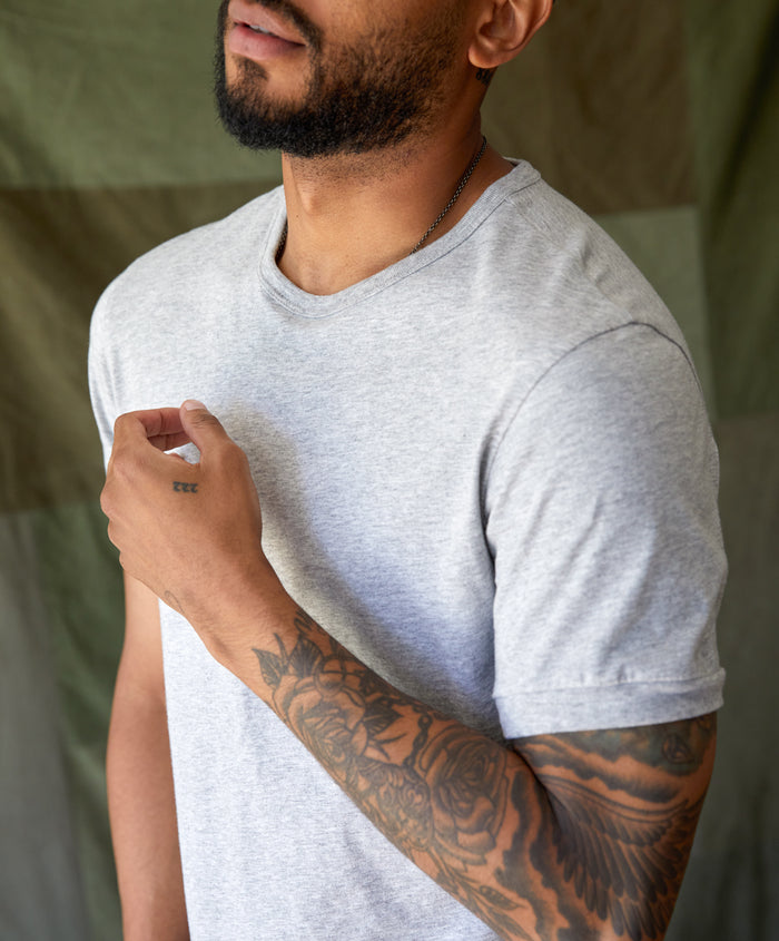 Man wearing a gray Sojourn tee by Outerknown, a men's short-sleeved t-shirt made with Peruvian Pima cotton.