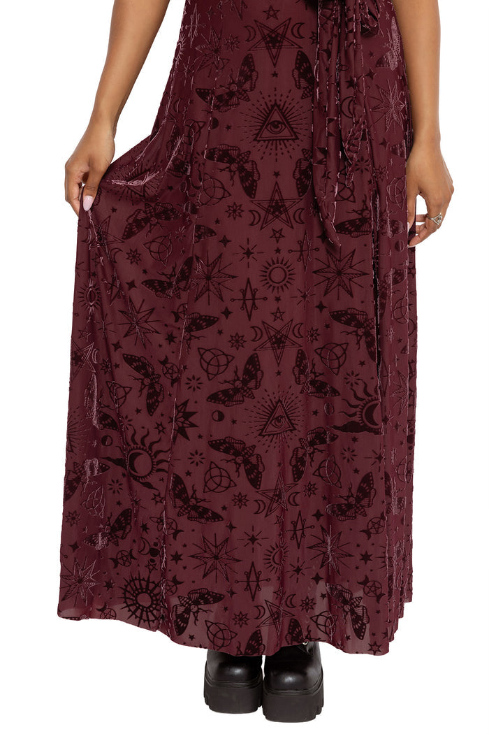 Dark fairycore kimono dress featuring occult symbols, stars, moons and mystical witch artwork across soft burned velvet fabric. This alternative witch dress blends gothic fashion and modern pagan aesthetics with wide flowing sleeves and a dramatic maxi silhouette.
