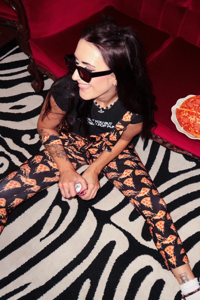 Side view of BlackMilk pizza overalls highlighting fitted legs, smooth fabric drape and adjustable strap construction