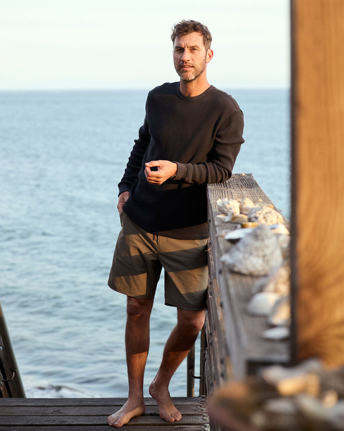 Man standing on a wooden dock by the ocean
