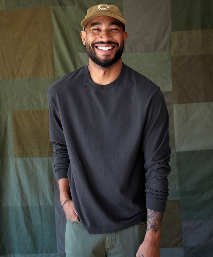 Man wearing black long sleeve t-shirt standing in a studio