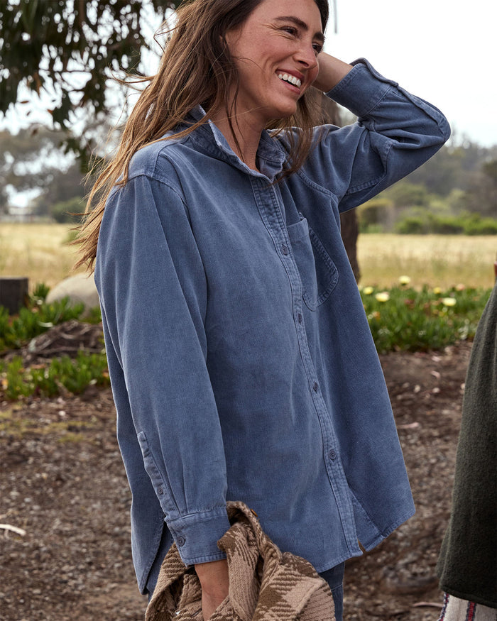 Woman wearing a blue corduroy shirt outdoors with a natural background