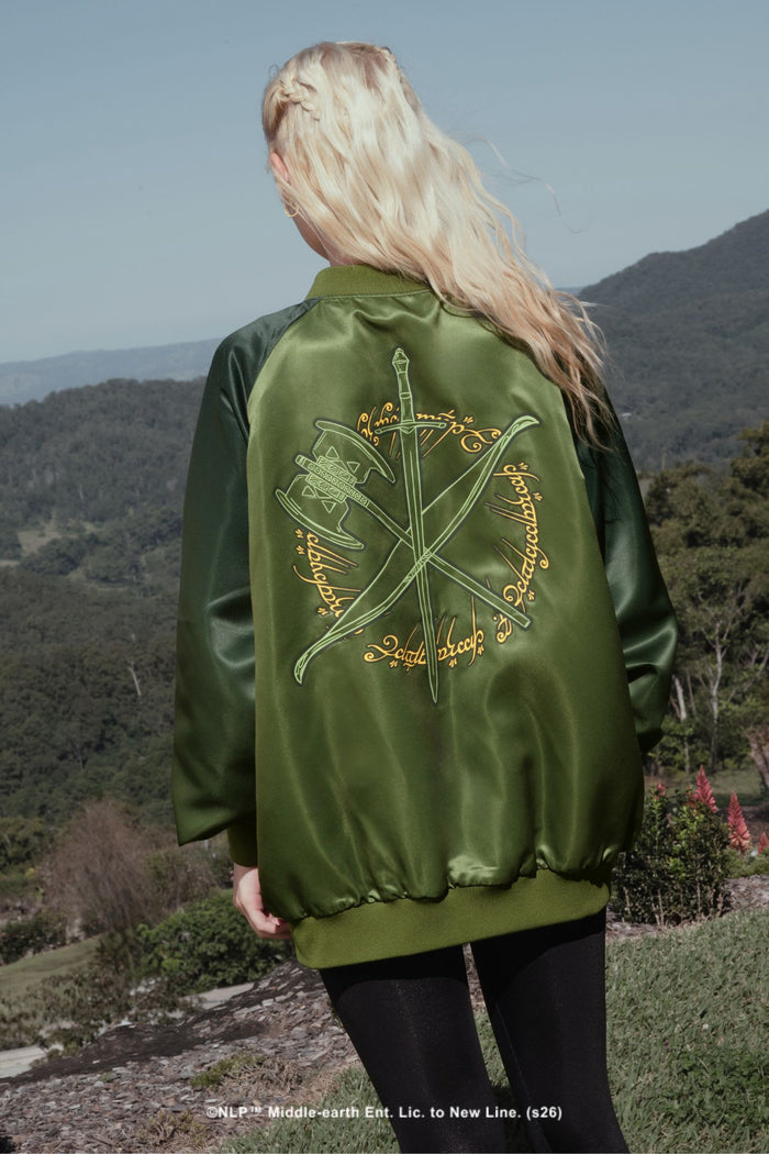 Close-up campaign shot of the Fellowship Souvenir Jacket by BlackMilk, showing the embroidered Lord of the Rings Fellowship graphics on green bomber jacket fabric.