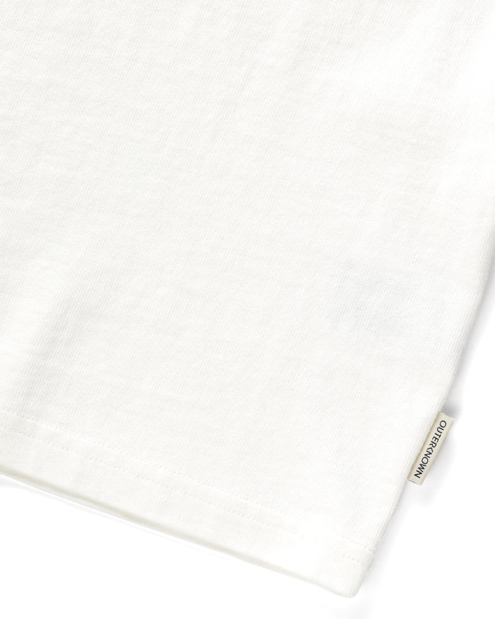 Close up of 'Outerknown' tag on seem of white short-sleeved t-shirt