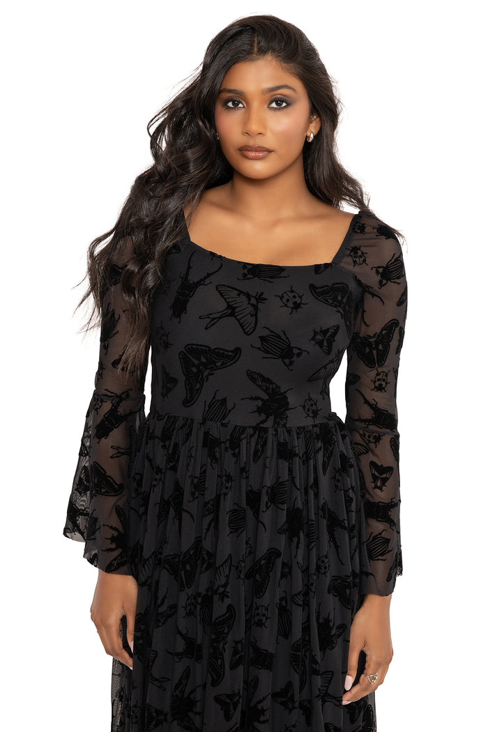 Whimsigoth flare sleeve maxi dress covered in Ami Raithe’s hand-drawn moth illustrations and gothic insect artwork. This dark fairycore dress combines alternative goth style with flowing mesh layers and romantic fantasy witch fashion energy.