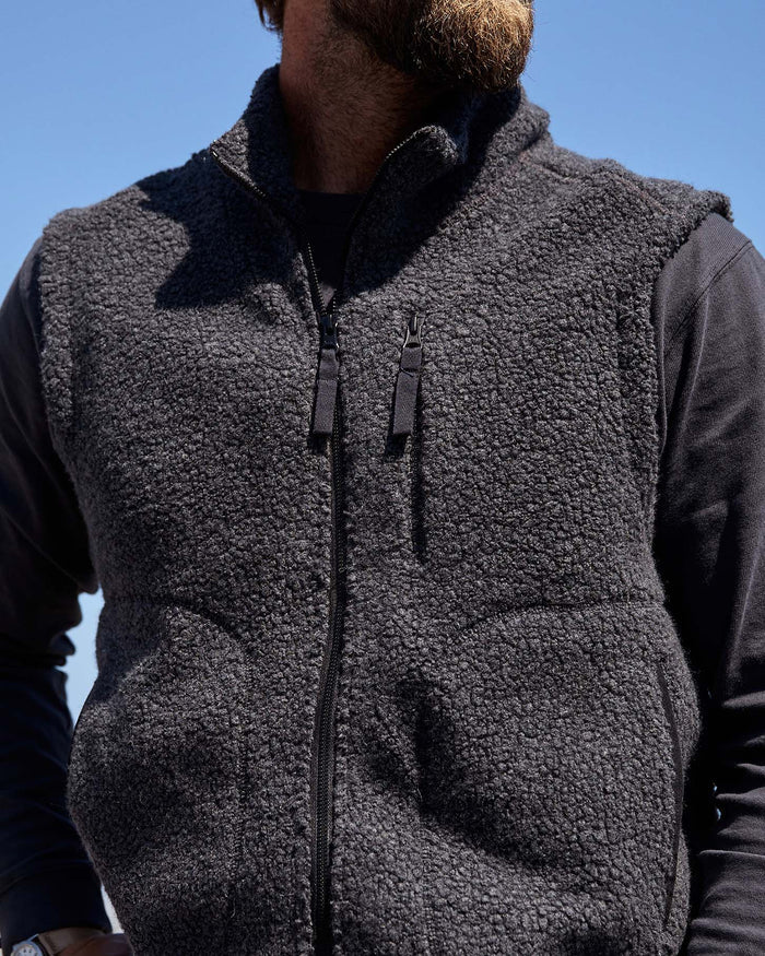 Close-up of a man wearing a black wool vest