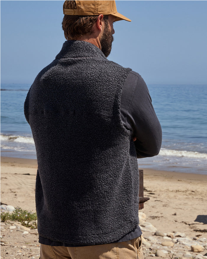 The back of a man wearing a black wool vest