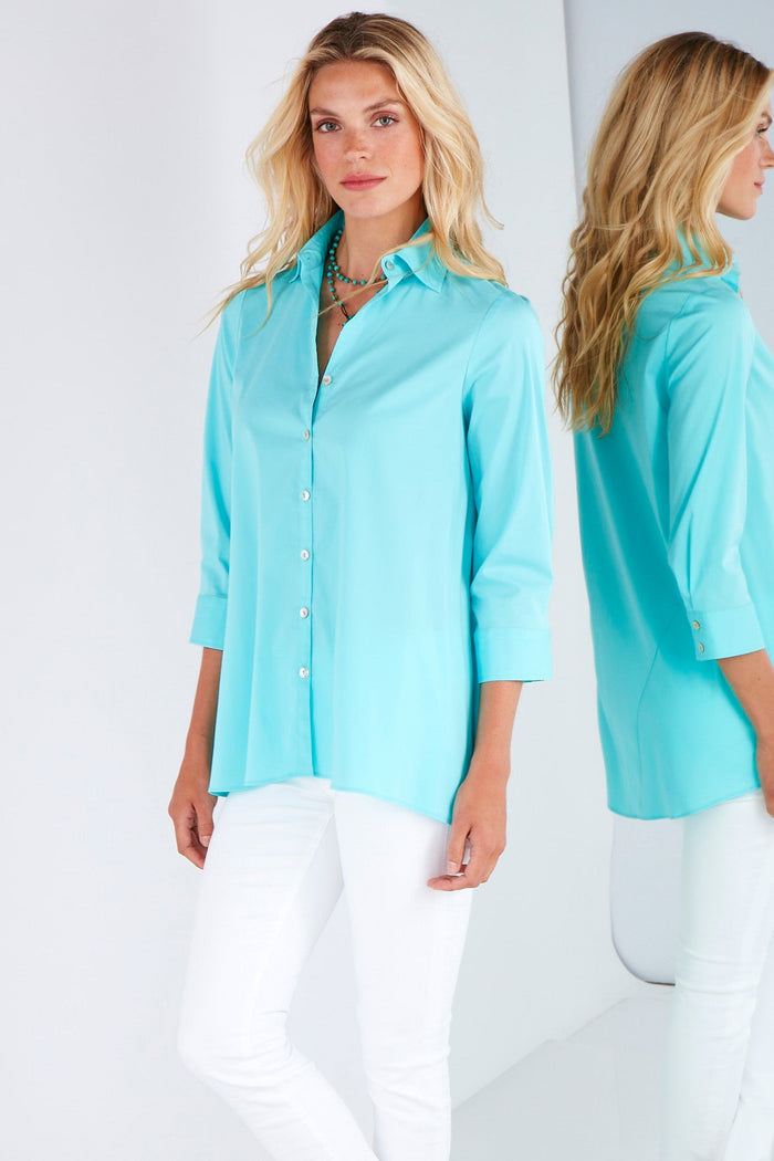 A fashion model wearing the Finley trapeze top, a black long-sleeve button-down blouse with a relaxed fit and an A-line shape.