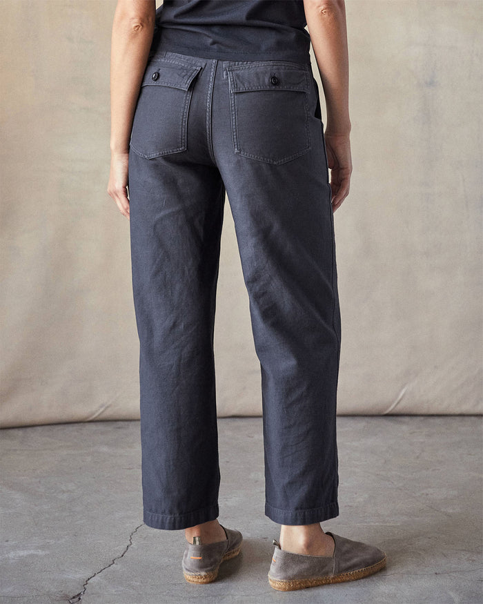 Person wearing dark pants against a neutral background