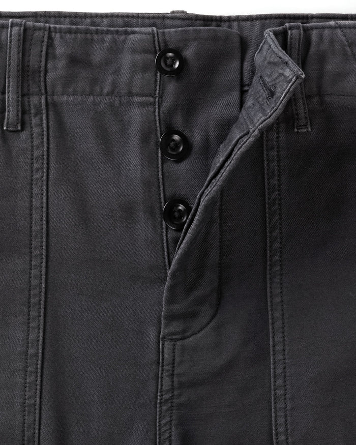 Close-up of dark gray pants with button details