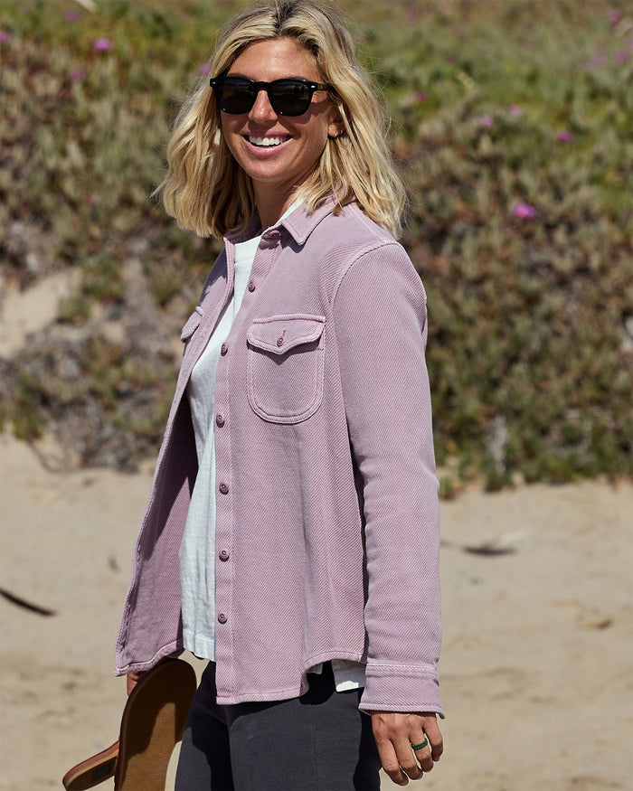 Woman wearing a pastel pink blanket shirt on the beach
